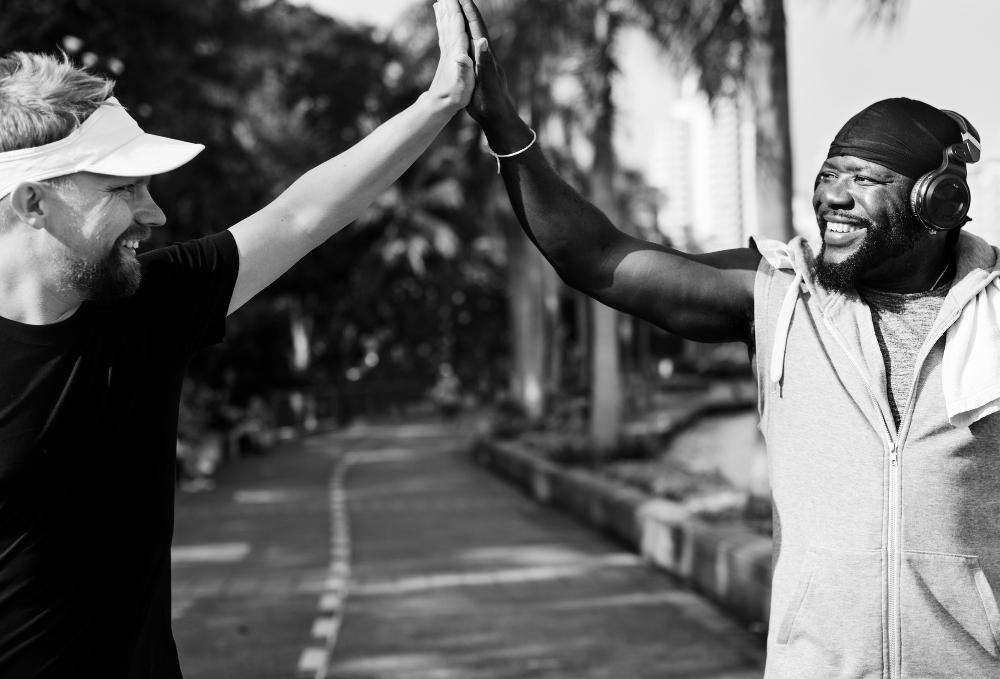 Two men high fiving after recovery workout