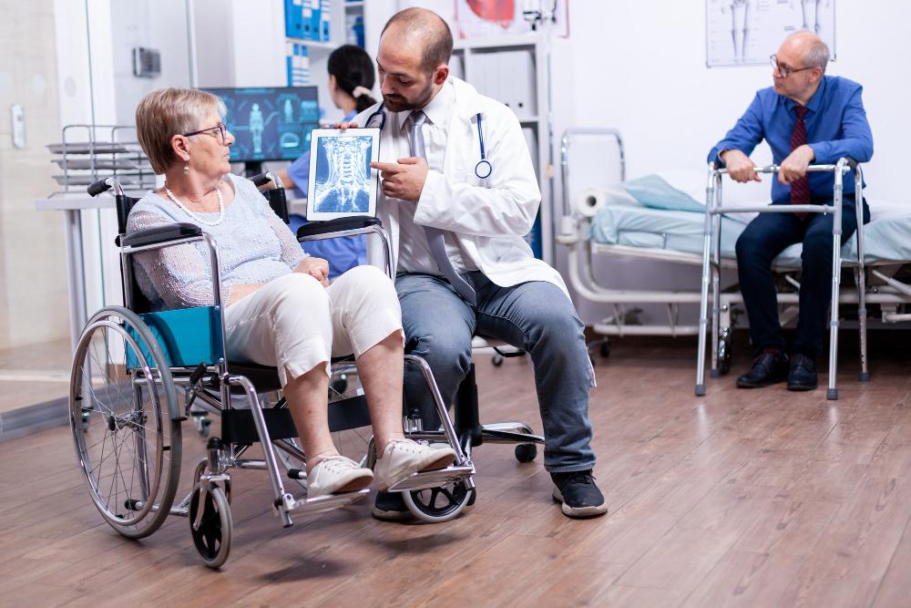 Doctor showing x-ray scan results to patient in wheelchair